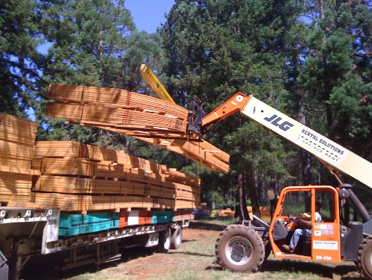 roof trusses being unloaded at the job site for a panelized framing kit
